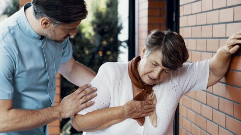 Frau fasst sich beim spazieren gehen an die Brust