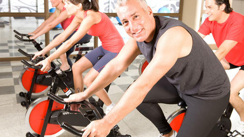 Mann im Fitnessstudio auf Ergometer