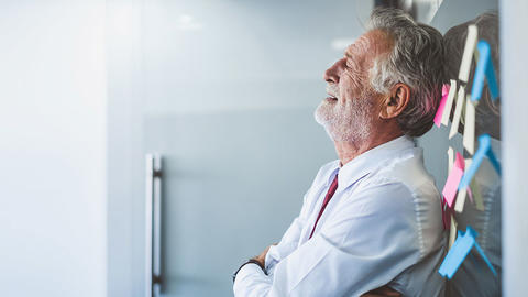 Mann lehnt sich an die Pinnwand