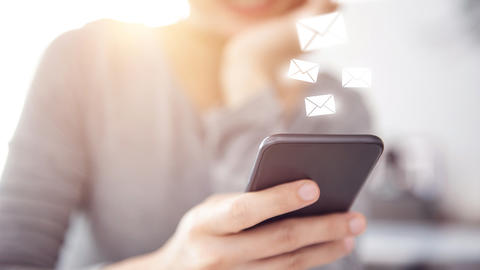 Frau schaut auf Ihr Handy und bekommt eine Nachricht
