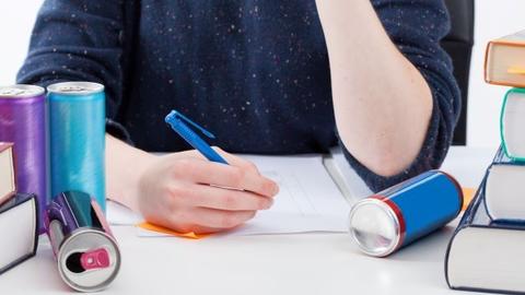 Jugendlicher hält sich mit Energy Drinks wach beim Lernen