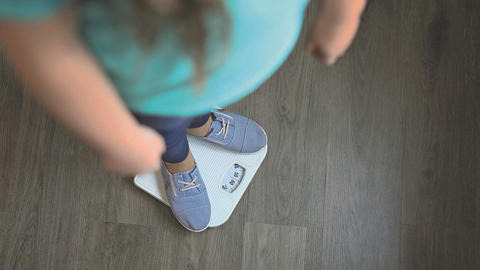 Frau steht auf Waage