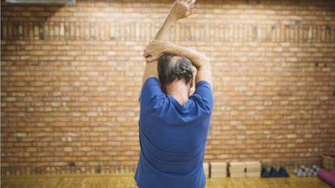 Senior dehnt sich beim Sport